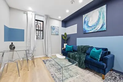 a living room with a blue couch and a table at SWJ544 - Chic 1BR in the Heart of NYC in New York