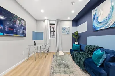 a living room with a blue couch and a table at SWJ544 - Chic 1BR in the Heart of NYC in New York