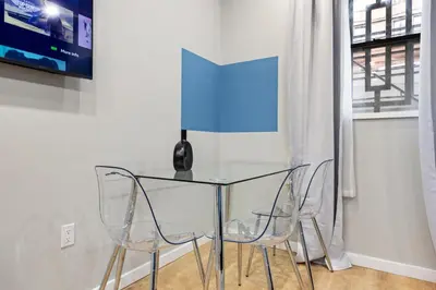 a glass table with two chairs and a vase on it at SWJ544 - Chic 1BR in the Heart of NYC in New York