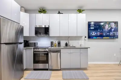 a kitchen with white cabinets and stainless steel appliances at SWJ544 - Chic 1BR in the Heart of NYC in New York
