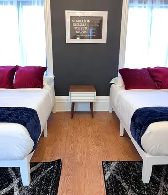 two beds in a room with red pillows and a table at SWJ544 - Spacious 5BR with Chef's Kitchen in New York