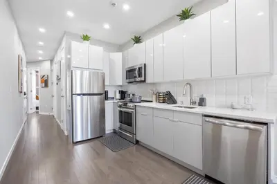 a kitchen with white cabinets and a stainless steel refrigerator at SWJ544 - Spacious 5BR with Chef's Kitchen in New York