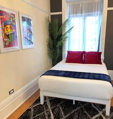 a bedroom with a bed with red pillows and a window at SWJ544 - Spacious 5BR with Chef's Kitchen in New York