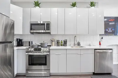 a kitchen with white cabinets and stainless steel appliances at SWJ544 - Spacious 5BR with Chef's Kitchen in New York