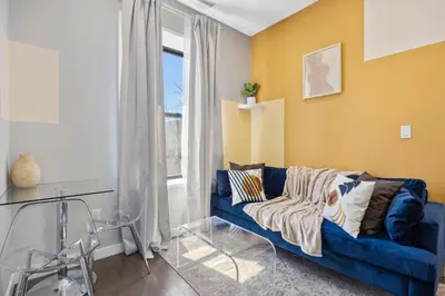 a living room with a blue couch and a window at SWJ544 - Spacious 5BR with Chef's Kitchen in New York