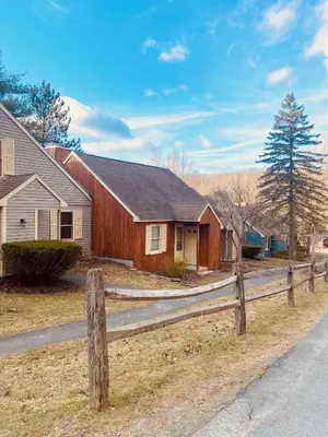 a wooden fence in front of a house at Cozy Ski in out Cabin in Berkshire Resort in Hancock