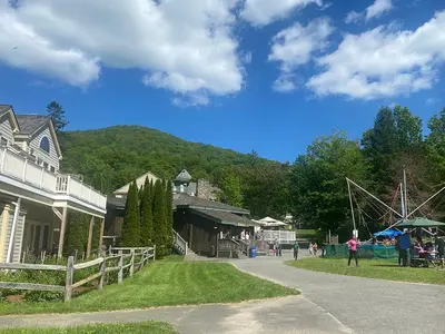 a group of people walking around a town with a amusement park at Cozy Ski in out Cabin in Berkshire Resort in Hancock