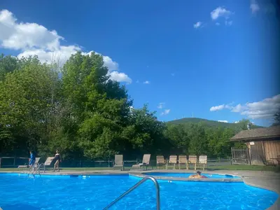a large blue swimming pool with a person in it at Cozy Ski in out Cabin in Berkshire Resort in Hancock