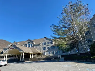 a building with a car parked in a parking lot at Cozy Ski in out Cabin in Berkshire Resort in Hancock
