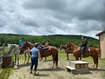 a group of people riding horses in a field at Cozy Ski in out Cabin in Berkshire Resort in Hancock
