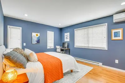 a bedroom with blue walls and a bed with an orange blanket at Pet-Friendly Hopewell Junction Home with Pool in Hopewell Junction