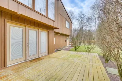 a house with a wooden deck in front of it at Pet-Friendly Hopewell Junction Home with Pool in Hopewell Junction