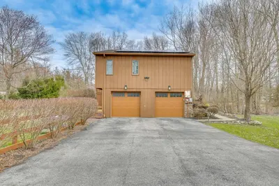 a house with a garage with a driveway at Pet-Friendly Hopewell Junction Home with Pool in Hopewell Junction