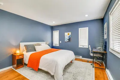 a bedroom with blue walls and a bed with an orange blanket at Pet-Friendly Hopewell Junction Home with Pool in Hopewell Junction