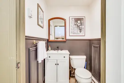 a bathroom with a toilet and a sink and a mirror at Pet-Friendly Hopewell Junction Home with Pool in Hopewell Junction