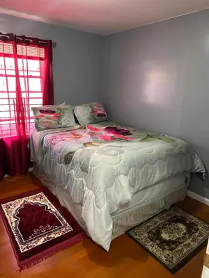 a large bed in a bedroom with red curtains at Divine Villa and Resorts 67 Sherman 5mins to EWR Airport and 4mins to Penn Station Newark, 20Mins to New York in Newark