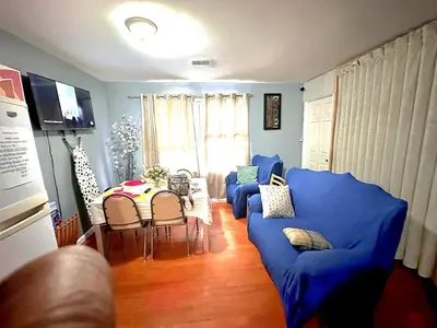 a living room with a blue couch and a table at Divine Villa and Resorts 67 Sherman 5mins to EWR Airport and 4mins to Penn Station Newark, 20Mins to New York in Newark