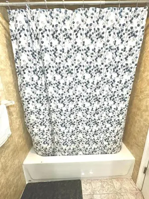a bathroom with a shower curtain with flowers on it at Room G DIVINE VILLA AND RESORT, 6 MINS TO AIRPORT, 4MINS TO PENN STATION. in Newark