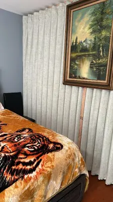 a bedroom with a painting on the wall and a bed at Room G DIVINE VILLA AND RESORT, 6 MINS TO AIRPORT, 4MINS TO PENN STATION. in Newark
