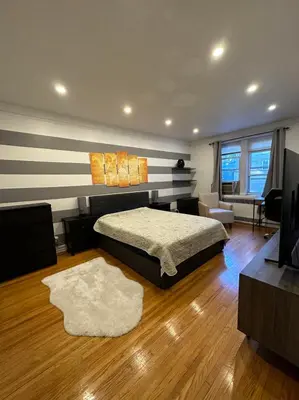 a bedroom with a bed and a television in a room at 2 Large Bedrooms In Rego Park in Rego Park