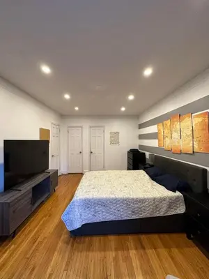 a bedroom with a large bed and a flat screen tv at 2 Large Bedrooms In Rego Park in Rego Park