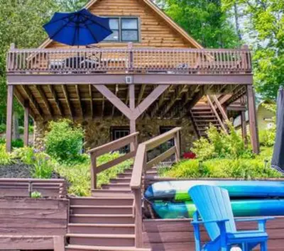 a house with a deck with an umbrella and a pool at Colgate Cabin #6 in Hamilton