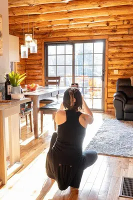a woman sitting on the floor in a living room at Colgate Cabin #6 in Hamilton