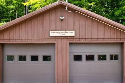 a garage with two garage doors and a sign on it at Colgate Cabin #6 in Hamilton