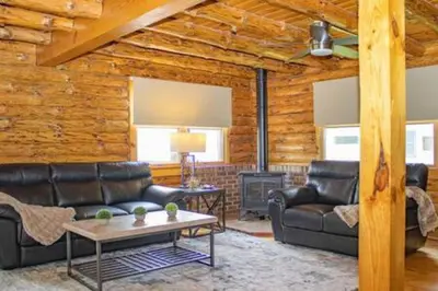 a living room with leather furniture and a fireplace at Colgate Cabin #6 in Hamilton