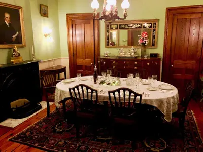 a dining room with a table with chairs and a mirror at Oakcliff Bed and Breakfast in Halfmoon
