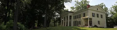 a white house on a hill with trees at Oakcliff Bed and Breakfast in Halfmoon