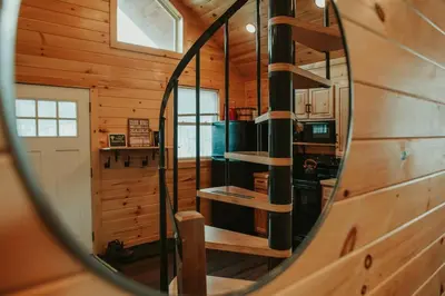a mirror reflection of a wooden cabin with a spiral staircase at Mountainscape: Peaceful & Skiing in Roxbury