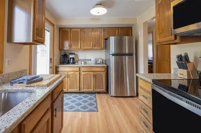 a kitchen with wooden cabinets and a stainless steel refrigerator at Lake Front Home #5 in Hamilton