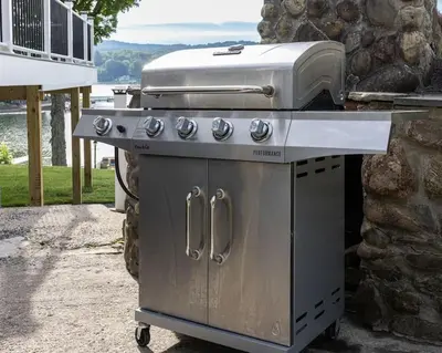 a grill sitting on a patio next to a stone wall at Lake Front Home #5 in Hamilton