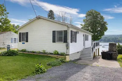 a small white house with a porch and stairs at Lake Front Home #5 in Hamilton