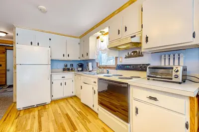 a kitchen with white cabinets and a white refrigerator at Little Bend Haven in Wilmington