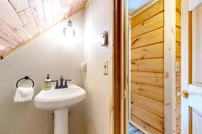 a bathroom with a white sink and a wooden door at Little Bend Haven in Wilmington