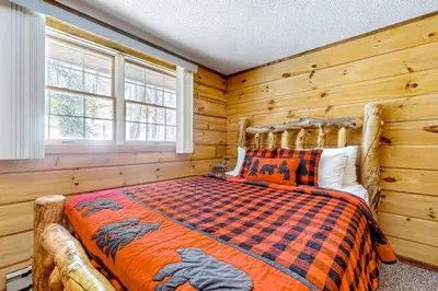a bedroom with a bed in a room with wooden walls at Little Bend Haven in Wilmington