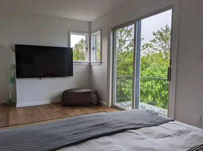 a bedroom with a bed and a flat screen tv at Hudson River Cliff House in Saugerties