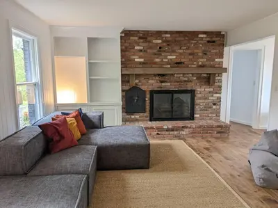 a living room with a couch and a fireplace at Hudson River Cliff House in Saugerties