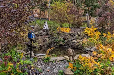 a garden with a pond and a statue in a yard at Hot Tub and Large Yard Elegant Deansboro Getaway in Deansboro
