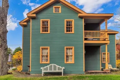 a green house with a bench in front of it at Hot Tub and Large Yard Elegant Deansboro Getaway in Deansboro