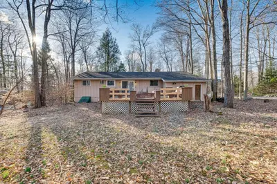 a house in the middle of the woods at Game Room and Fire Pit Chic Pocono Pines Home! in Pocono Pines