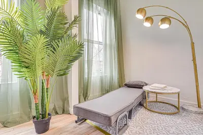 a room with a bench and a large plant at Downtown Albany Vacation Rental - Chic and Walkable! in Albany