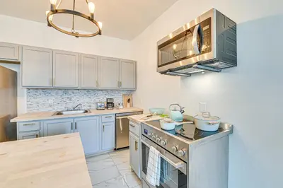 a kitchen with white cabinets and a stove top oven at Downtown Albany Vacation Rental - Chic and Walkable! in Albany