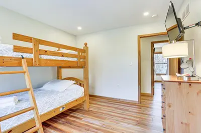 a bedroom with two bunk beds and a desk at Forest-View Deck and Fire Pit Poconos Escape! in East Stroudsburg