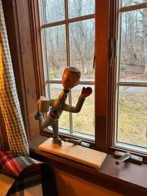 a wooden figurine sitting on a window sill at STREAMSIDE CABIN IN THE CATSKILLS in Chichester