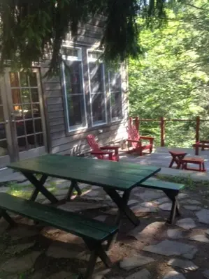 a green picnic table in front of a house at STREAMSIDE CABIN IN THE CATSKILLS in Chichester