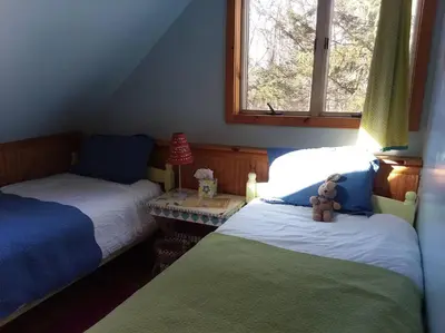 a bedroom with two beds and a teddy bear on the bed at STREAMSIDE CABIN IN THE CATSKILLS in Chichester
