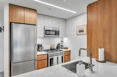 a kitchen with a stainless steel refrigerator and a stove at Prime NYC Waterfront Gem in Mott Haven